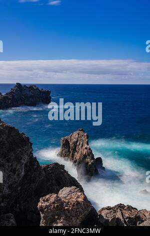 Rocce vulcaniche nell'oceano Atlantico, fotografia a lunga esposizione, vista dell'orizzonte con luce solare pomeridiana, Icod de los Vinos, Tenerife, Isole Canarie, Spagna Foto Stock
