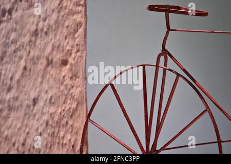 Vintage antico ghisa Velocipede replica contro un muro di pietra a Santorini isola, Cicladi Grecia. Foto Stock