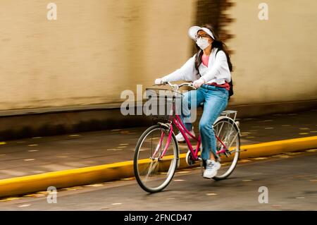 Una donna si snoda lungo Anxi Road nel distretto di Changning di Shanghai, in Cina. Foto Stock