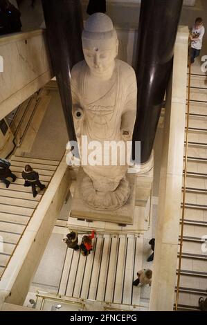 Londra, Regno Unito: L'imponente statua del Buddha situata nelle scale nord del British Museum Foto Stock