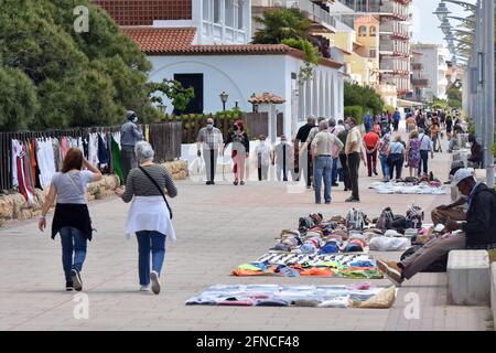 Vendrell, Spagna. 16 maggio 2021. Molte persone che indossano maschere facciali come misura preventiva contro Covid-19 camminano oltre i venditori illegali di strada a Vendrell dal 9 maggio, il governo decretato la fine dello stato di allarme in Spagna, la gente sta ritornando allo stato di normalità prima della pandemia. Ristoranti, commercio, turismo e vita quotidiana continuano con misure preventive come l'uso di maschere e il mantenimento della distanza sociale. Credit: SOPA Images Limited/Alamy Live News Foto Stock