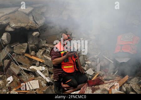 (210516) -- GAZA, 16 maggio 2021 (Xinhua) -- i membri della difesa civile palestinese cercano corpi o sopravvissuti sotto le macerie di case distrutte a seguito di attacchi aerei israeliani in via al-Wahda nel centro della città di Gaza, il 16 maggio 2021. La tensione tra Israele e i gruppi militanti nella striscia di Gaza è continuata domenica per il settimo giorno di fila, mentre il numero di vittime nell'enclave costiera è salito a 181 e altri 1,225 sono stati feriti, ha detto i funzionari. Credit: Xinhua/Alamy Live News Foto Stock