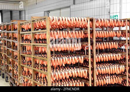 Salsicce in rack in una fabbrica Foto Stock