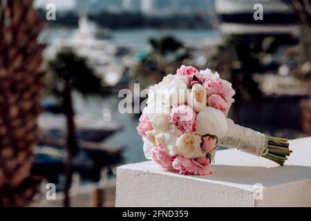 Bouquet nuziale su uno sfondo di palme e molo con yacht Foto Stock