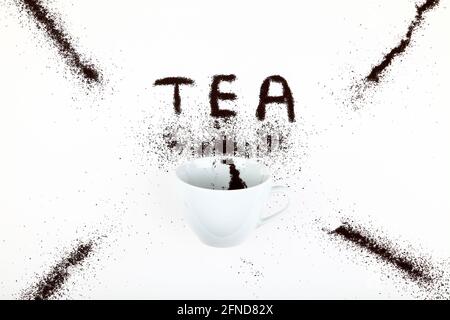 Tazza di tè con le foglie di tè che fuoriescono creando la parola tè Foto Stock