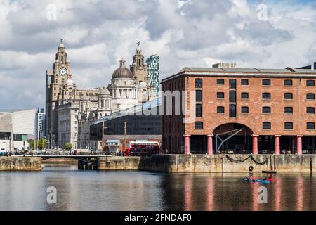 Canoe nell'Albert Dock visto nel maggio 2021 sullo splendido sfondo delle tre grazie sullo skyline di Liverpool. Foto Stock