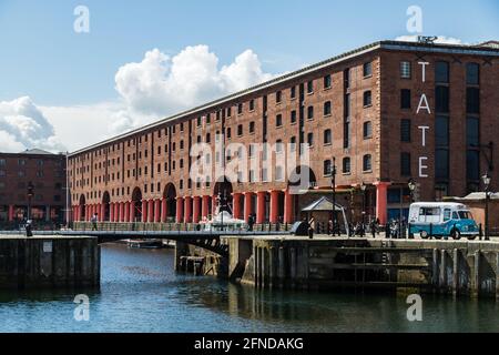 Guardando dall'altra parte dell'acqua fino all'entrata principale dell'Albert Dock sul famosissimo lungomare di Liverpool nel maggio 2021. Foto Stock