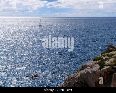 Splendida vista dello yacht solitario in mare aperto. Vista dall'alto dalla scogliera. Foto Stock