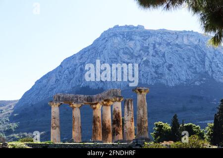 Vista della fortezza di Acrocorinto dall'antica Corinto, Grecia con pilastri del Tempio di Apollo in primo piano Foto Stock