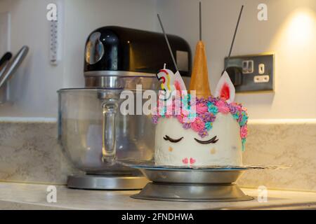 Primo piano di una torta di compleanno decorata unicorno su una cucina contatore Foto Stock