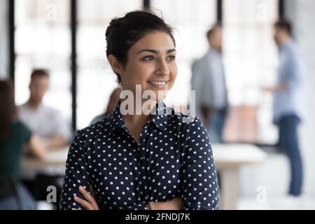 Fiducioso sorridente leader del gruppo femminile indiano guardando la finestra Foto Stock