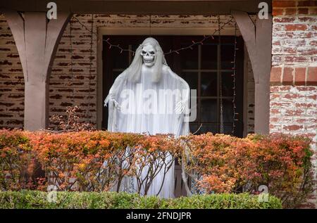 Fantasma di zombie in piedi sul portico dietro la siepe colorata autunno per Decorazione di Halloween Foto Stock