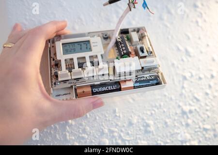 Collegamento di cavi codificati durante l'installazione di Google Nest Learning termostato durante un progetto di ristrutturazione intelligente della casa a Lafayette, California, 17 gennaio 2021. () Foto Stock