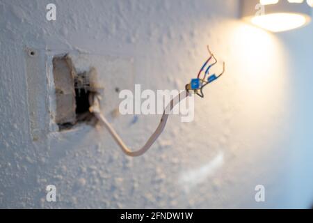 Collegamento di cavi codificati durante l'installazione di Google Nest Learning termostato durante un progetto di ristrutturazione intelligente della casa a Lafayette, California, 17 gennaio 2021. () Foto Stock