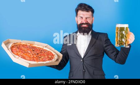 Consegna pizza. Uomo sorridente con pizza e birra. Cucina italiana. Fast food. Foto Stock