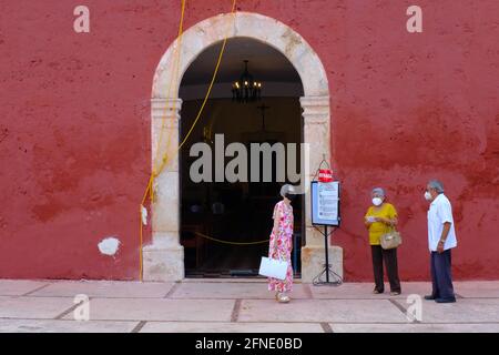 I churchgoers che indossano le maschere di fronte alla chiesa durante il Covid-19 Pandemic, Merida Messico Foto Stock