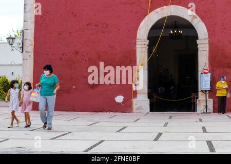 I churchgoers che indossano le maschere di fronte alla chiesa durante il Covid-19 Pandemic, Merida Messico Foto Stock