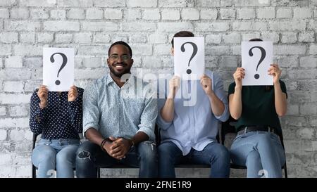 Felice candidato di lavoro che celebra l'intervista riuscita, seduta vicino ai competitori guasti Foto Stock