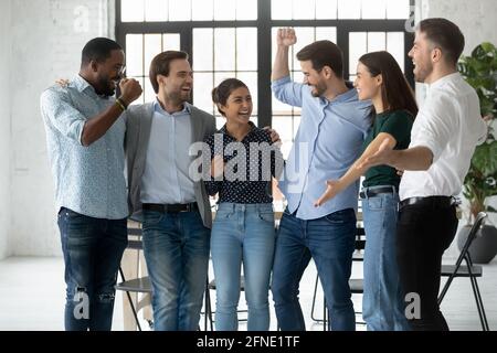 I colleghi motivati e entusiasti gridano per la gioia e celebrano il successo del team Foto Stock