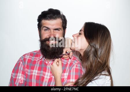 Pubblicità Barbiere. Uomo bearded in barbiere. Il parrucchiere taglia la barba. Rifinitura dei peli del viso. Styling dei capelli. Foto Stock