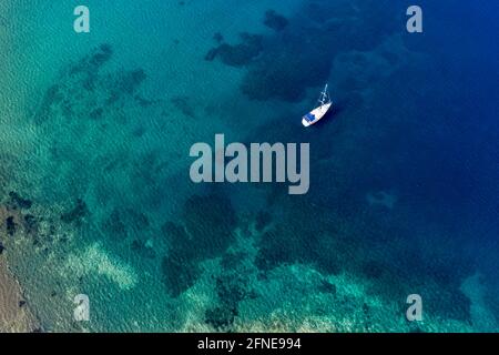 Aereo di una barca a vela nelle acque limpide della spiaggia di Limnionas, Samos, Grecia Foto Stock