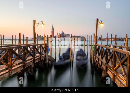 Pier con gondole veneziane, nella chiesa di San Giorgio maggiore, esposizione lunga, alba, Venezia, Veneto, Italia Foto Stock