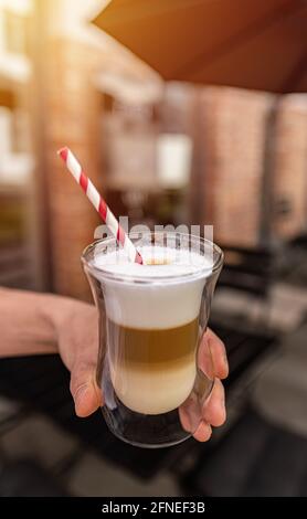 Allettante bicchiere di latte macchiato servito a strati e condito con crema Foto Stock