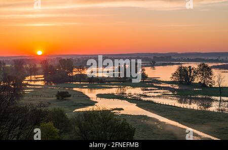 Lebus, Germania. 11 Maggio 2021. L'alba risplende di colore sul paesaggio sul fiume Oder, confine tedesco-polacco, ai margini dell'Oderbruch, nel Brandeburgo orientale. Credit: Patrick Pleul/dpa-Zentralbild/ZB/dpa/Alamy Live News Foto Stock