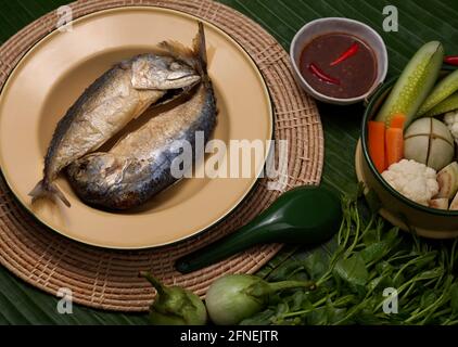 Vista dall'alto di sgombri fritti con salsa di pasta di gamberi e. Set di verdure servito su piatti tradizionali thailandesi decorati con banana foglie Foto Stock