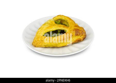 Puff panino triangolare con spinaci su piatto di porcellana bianca, isolato su fondo bianco. Foto Stock