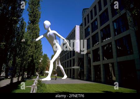 La scultura alta casa del 'Walking Man' dell'artista Jonathan Borofsky di fronte alla riassicurazione di Monaco a Schwabing. [traduzione automatizzata] Foto Stock