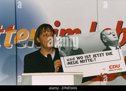 "Il Segretario generale della CDU Angela Merkel ad una conferenza stampa a Bonn. Lei tiene un segno, sul segno si può vedere il politico verde Jürgen Trittin a sinistra e il politico di sinistra Oskar Lafontaine a destra e si legge: ''e dove è il nuovo centro ora?' [traduzione automatizzata]" Foto Stock