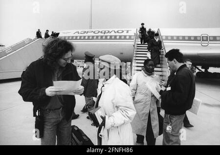 I membri dei servizi sociali ricevono i rifugiati dal Togo all'aeroporto Franz Josef Strauß di Monaco che erano arrivati su un aereo Aeroflot da Mosca. [traduzione automatizzata] Foto Stock