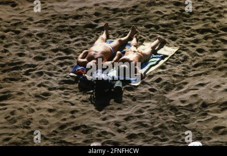 I turisti prendono il sole sulla spiaggia di Playa del Ingles a Gran Canaria. [traduzione automatizzata] Foto Stock