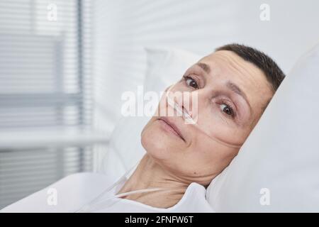 Ritratto di donna matura sdraiata sul letto e curata a. ospedale Foto Stock