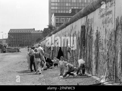 Berlin-Boroughs / GDR / 1990 Kreuzberg: A metà del 1990 il muro è già molto martoriato. I picchietti hanno battuto i pezzi ovunque, come qui a Zimmerstrasse. Sul retro, la sede della casa editrice Springer. // Muro di Berlino / parete della DDR /Storia / comunismo [traduzione automatizzata] Foto Stock