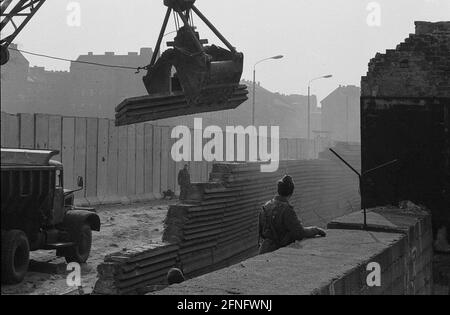 Berlino-Città / GDR / 20.3.1980 Bernauer Strasse in matrimonio. Le vecchie pietre di parete sono sostituite da elementi a L in calcestruzzo liscio. La giovane guardia di frontiera si trova lì per sorvegliare i lavoratori edili. Per impedire loro di fuggire in Occidente. // DDR / Muro / distretti / Soldato / Storia / comunismo [traduzione automatizzata] Foto Stock
