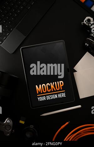 Vista dall'alto del tablet digitale mock-up sul tavolo nero con dispositivi digitali e fotocamera Foto Stock