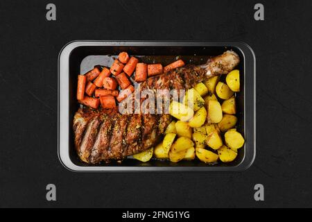 Vista dall'alto della spalla di agnello al forno con patate e carota in forno-vassoio Foto Stock