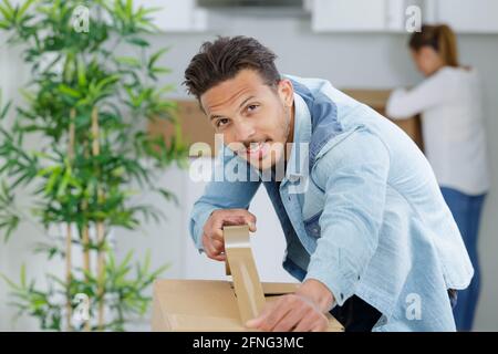 man taping scatole per muoversi in nuovo appartamento Foto Stock