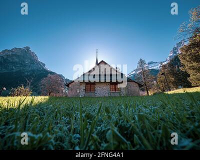 Bella vecchia chiesa rustica alpina e montagne innevate. La chiesa si trova nel villaggio alpino di kandersteg in Svizzera. Foto Stock