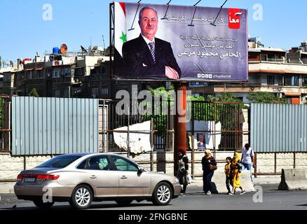 (210517) -- DAMASCO, 17 maggio 2021 (Xinhua) -- UN manifesto di un candidato presidenziale siriano è visto a Damasco, Siria, 16 maggio 2021. Le campagne presidenziali siriane sono iniziate ufficialmente domenica come manifesti del presidente Bashar al-Assad e degli altri due candidati riempirono le piazze e le strade della capitale Damasco. (Foto di Ammar Safarjalani/Xinhua) Foto Stock