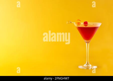 Tradizionale cocktail Manhattan con ciliegia su sfondo giallo Foto Stock