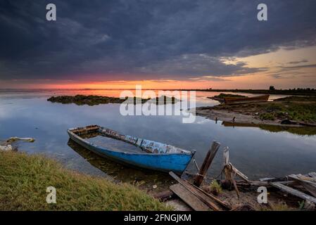 Barche in un'alba estiva nel cimitero navale della Baia di Fangar (Badia del Fangar), nel delta dell'Ebro (provincia di Tarragona, Catalogna, Spagna) Foto Stock