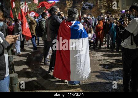 Santiago, Cile. 17 maggio 2021. Un uomo si copre con una bandiera cilena durante le celebrazioni.dopo due giorni di voto elettorale in Cile, dove il basso flusso di persone ha caratterizzato il processo democratico, I membri del Partito Comunista del Cile si riuniscono nelle vicinanze di Plaza Baquedano per celebrare il trionfo dei candidati eletti come elettori, l'elezione degli elettori è stata un processo storico nel paese. Credit: SOPA Images Limited/Alamy Live News Foto Stock