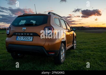 SUV compatto Dacia Duster su strada sterrata al tramonto Foto Stock