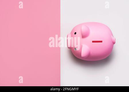 vista dall'alto della banca di denaro rosa piggy con spazio per la copia su sfondo rosa e bianco Foto Stock