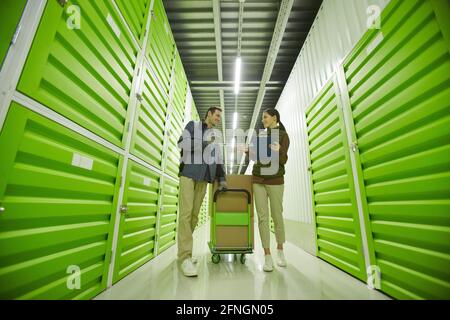 Due colleghi discutono della consegna dei pacchi mentre lavorano magazzino Foto Stock