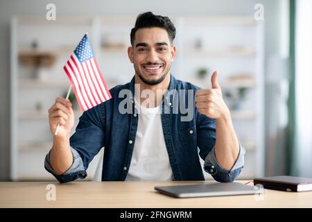 Ragazzo felice con bandiera degli Stati Uniti mostrando il pollice in su Foto Stock