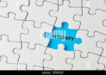 La parola integrità scritta su pezzo di puzzle blu mancante. Foto Stock